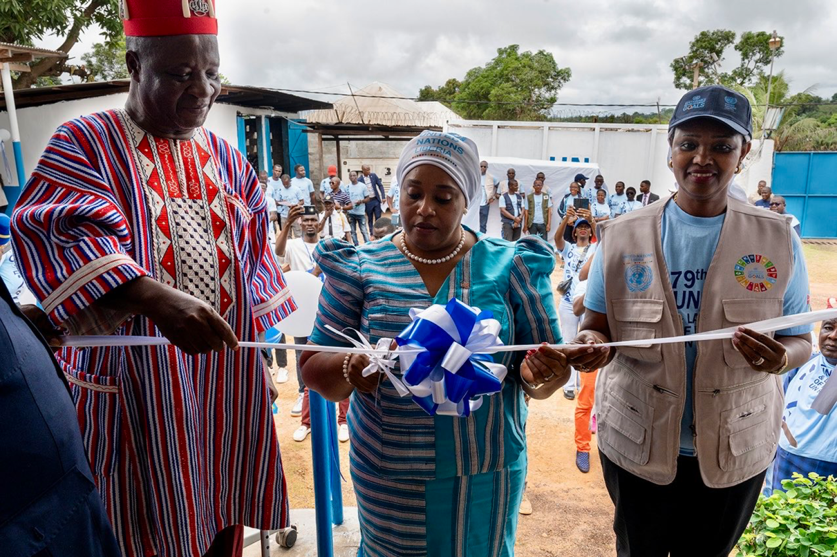 Three persons cutting a ribbon