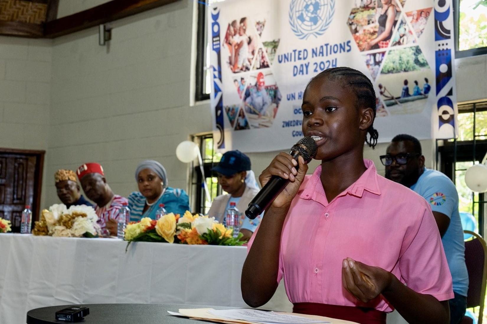 Young girl standing with a microphone in her hand.