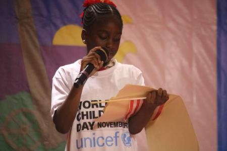 Girl wearing a white tshirt standing and holding a microphone