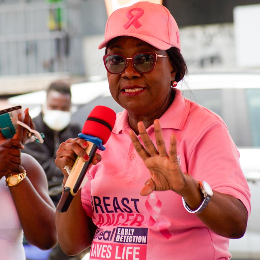 Women in pink shirt speaking with a microphone