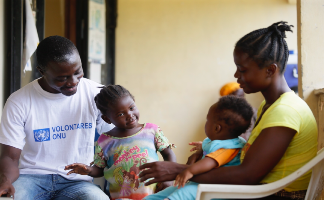 Roosevelt Gbamie Cooper, national UN Volunteer Associate Field Liaison Officer in Nimba county, discussing gender issues with a woman at the Nimba Gender Office. 