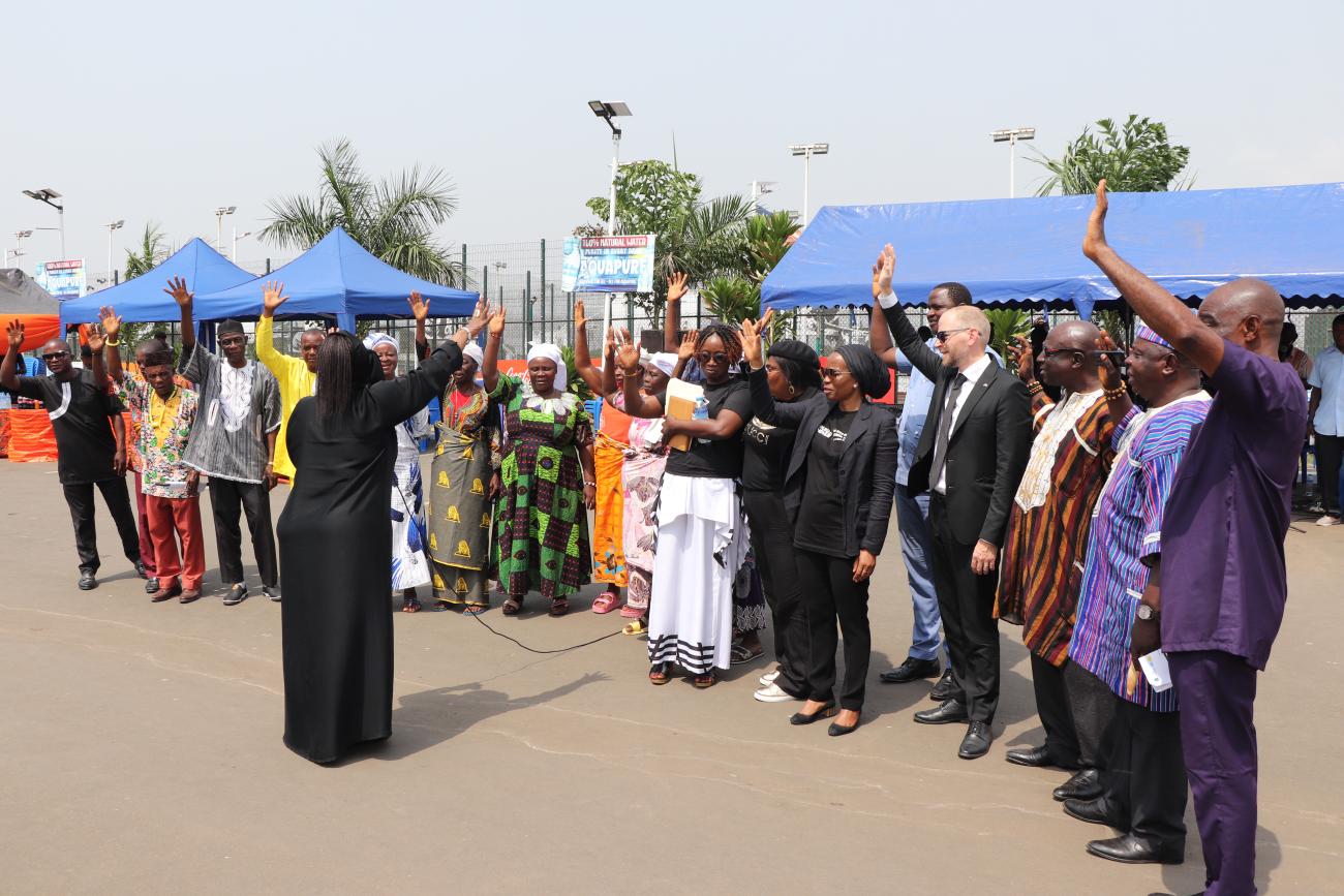 Photo of a people standing in a group with their arms raised