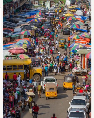 A street with vehicles moving and people walking 